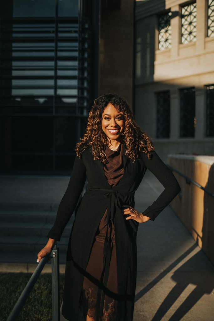 Picture of Jessica with left hand on hip and right hand on railing. 